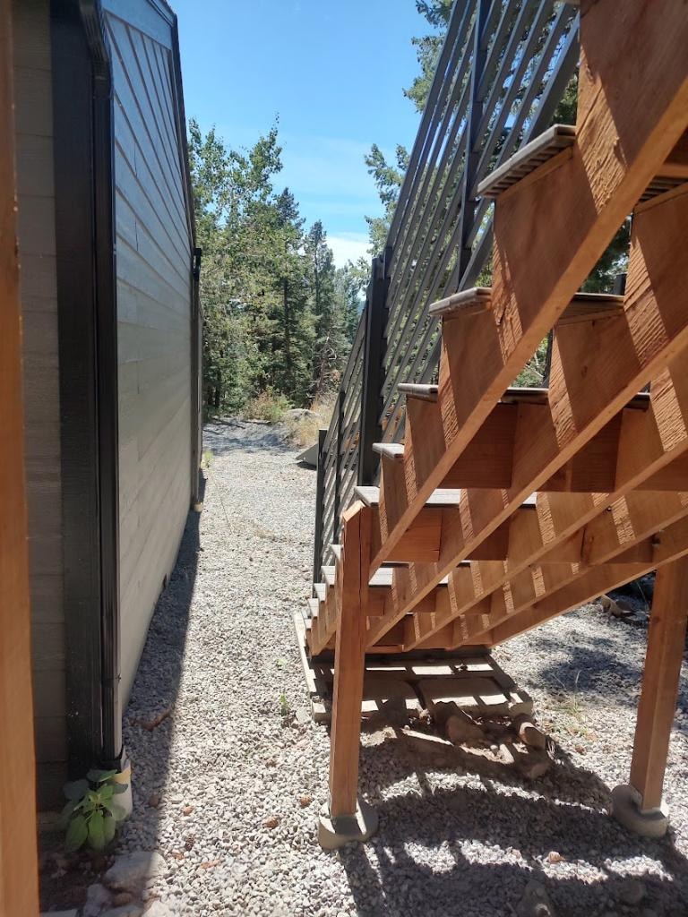 Completed deck stairs with metal railings and gravel ground cover